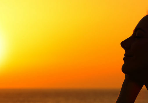 silhouette of a woman watching sunset at beach